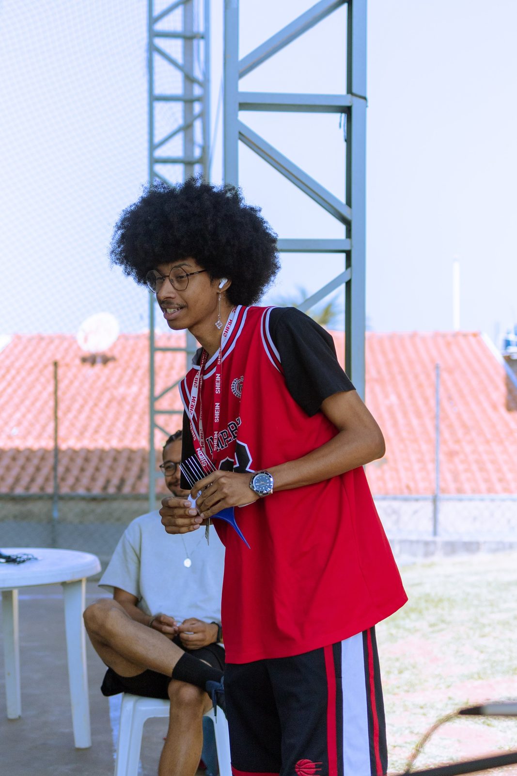 Jovem fala ao microfone em encontro territorial do Fórum de Juventudes
