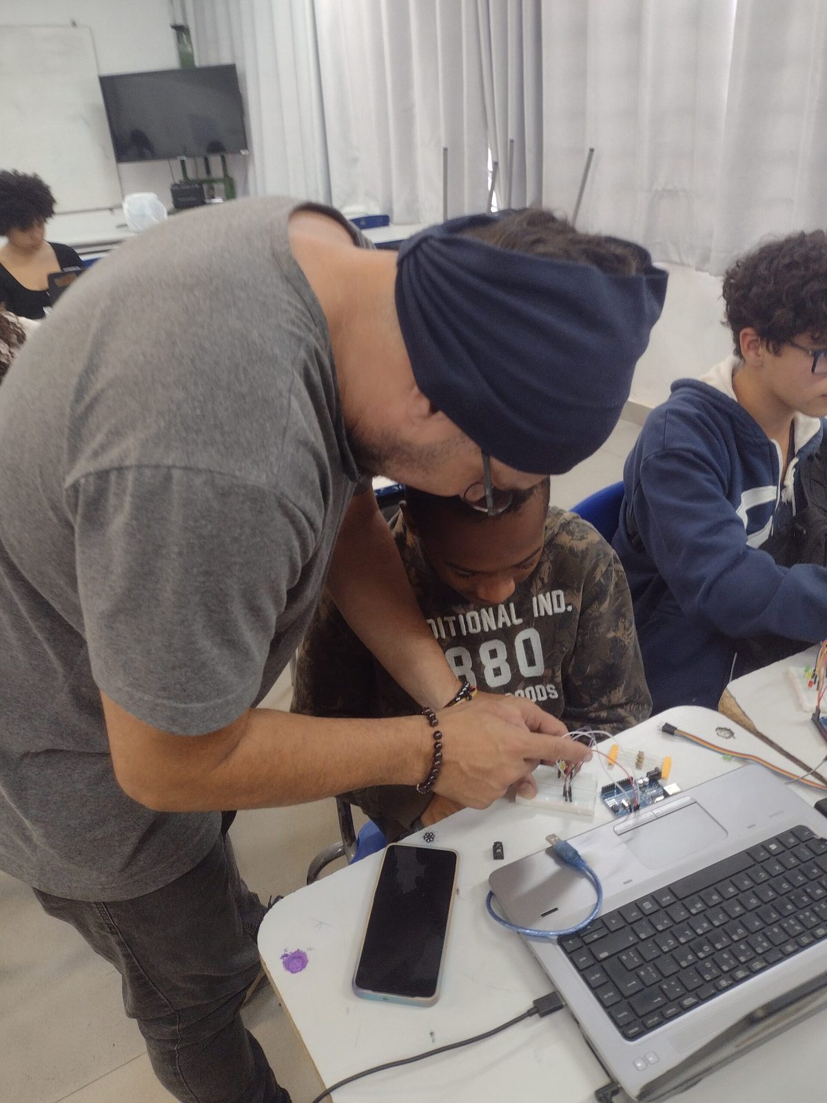 Jovens em oficina maker do Hackerclubes, montando eletrônica em grupo