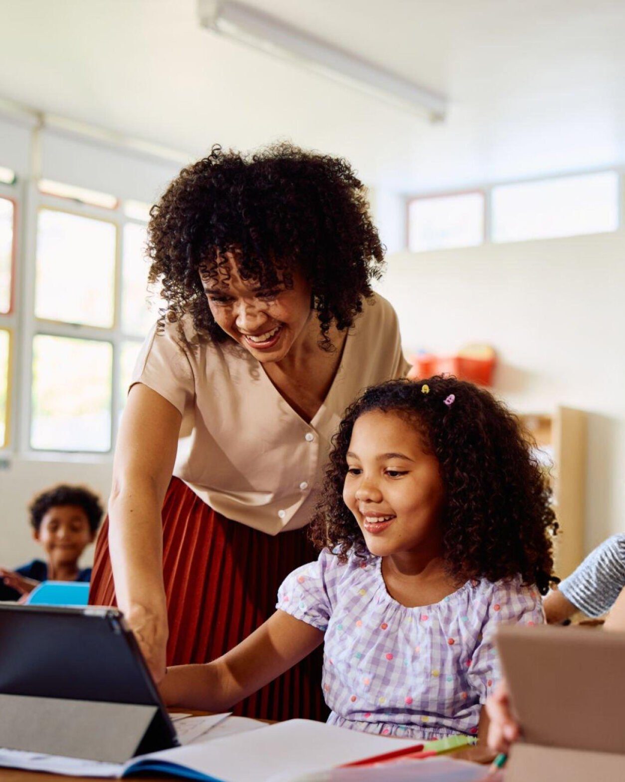 Educadora e criança diante de um tablet durante formação de cidadania digital