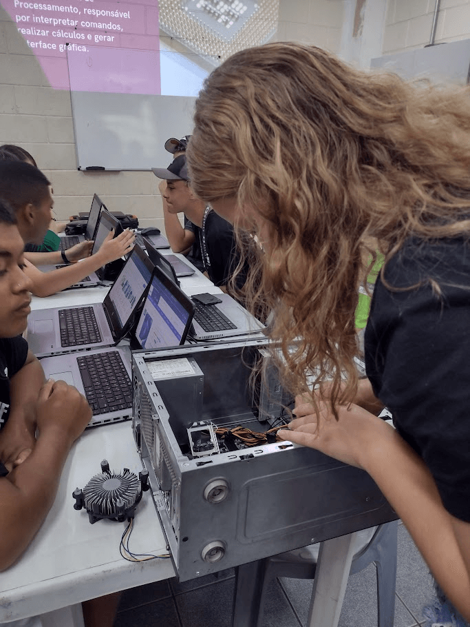 Aula de educação digital básica do Inclusão Tech em Campinas, com participantes em frente a notebooks